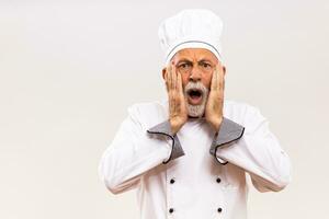 retrato de conmocionado mayor cocinero en gris antecedentes. foto