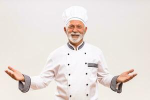 Portrait of senior chef gesturing  on gray background. photo