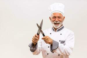 Image of happy chef sharpens knives on gray background. photo