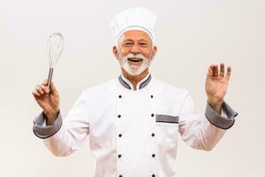 imagen de musical conductor mayor cocinero con cable batidor en gris antecedentes. foto