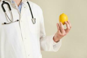 Image of male doctor holding lemon. photo