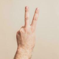 Close up image of male hand showing  victory sign. photo