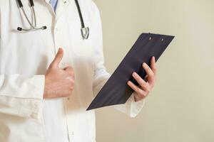 Image of male doctor showing thumb up and holding documents photo