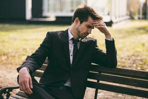 Worried businessman sitting outdoor.Toned image. photo