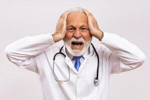 Image of  overworked senior doctor on gray background. photo