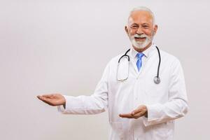 Portrait of doctor  showing welcome gesture on gray background. photo