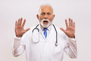 Portrait of  senior doctor in panic on gray background. photo