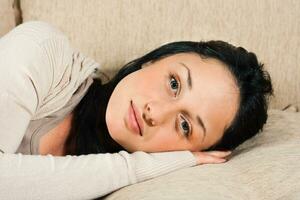 Young woman  lying on the sofa and looking at camera photo