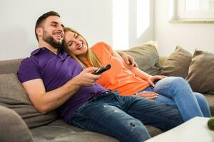 Happy couple enjoy watching tv and spending time together at their home. photo