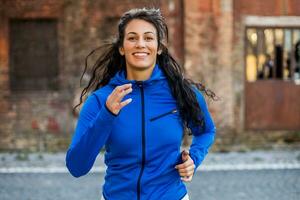 Beautiful young woman is jogging outdoor. photo