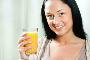 joven mujer Bebiendo Fresco naranja jugo foto