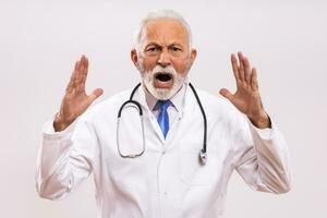 imagen de enojado mayor médico gritos en gris antecedentes. foto