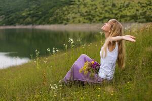 Woman with her arms outstretched enjoys spending her time in beautiful nature. photo