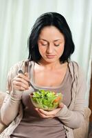 Woman enjoys eating salad photo