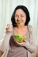 mujer disfruta comiendo ensalada foto