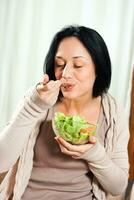 mujer disfruta comiendo ensalada foto