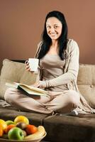 joven mujer leyendo libro y Bebiendo café foto