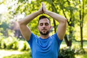 Handsome man meditating in the park. photo