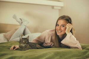 Beautiful woman and her cute cat enjoy spending time together.Toned image. photo