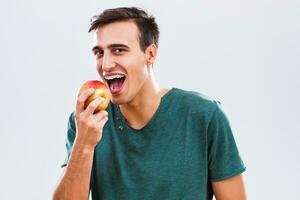 hombre con tirantes comiendo manzana foto