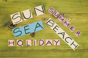 Hora de verano concepto con palabras sol,playa,verano,mar,vacaciones en de madera mesa.tonificada foto. foto