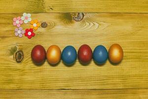 Painted Easter eggs   with petals on wooden table.Toned photo. photo