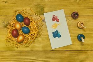 pintado Pascua de Resurrección huevos en Paja y colores para pintura en de madera mesa.tonificada foto. foto