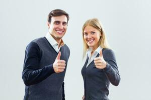 Businessman and businesswoman showing thumbs up photo