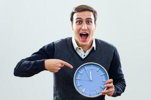 Excited businessman pointing at clock photo