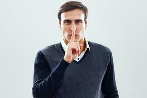 Businessman with finger on his lips photo