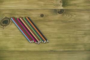 Colorful pencils on a wooden table photo