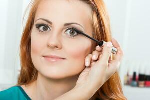 Make up artist applying  make up on a beautiful woman photo