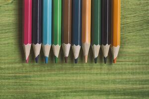 Image of crayons on wooden table.Toned image.Image contains little noise because of high ISO set on camera. photo