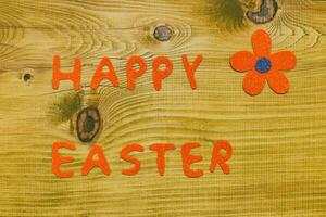 Happy Easter message with  flower on wooden table.Toned photo. photo