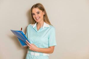 Portrait of beautiful nurse writing notes. photo