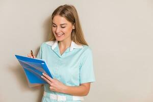 Portrait of beautiful nurse writing notes. photo