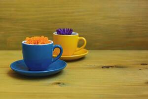 Beautiful flower petals in a cups on wooden background. photo