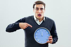 Businessman in panic pointing at clock photo