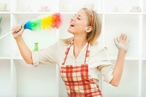 Cheerful housewife cleaning and singing photo