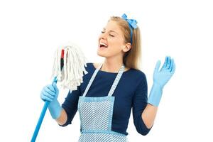 Cheerful housewife cleaning and singing photo