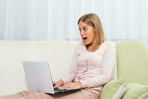 Excited woman using laptop photo