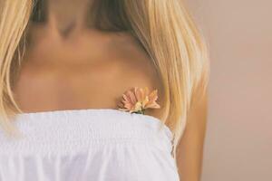 Close up portrait of woman with a little flower.Focus on flower. photo