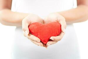 Close up image of woman holding red heart photo