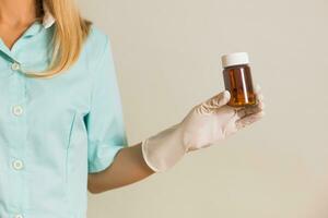 Image of medical nurse showing bottle of pills. photo