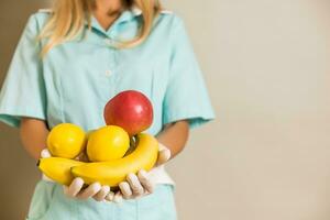 Image of medical nurse holding fruit. photo