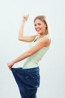 Happy woman in large jeans .Weigt loss concept. photo