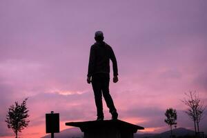 man silhouette in the countryside and beautiful sunset background photo