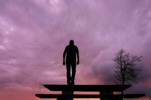 hombre silueta en el campo y hermosa puesta de sol antecedentes foto