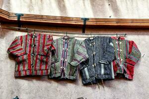 three colorful jackets hang on a wall photo