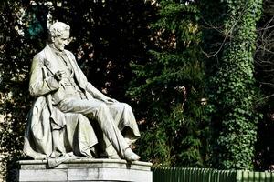 un estatua de un hombre sentado en un banco foto